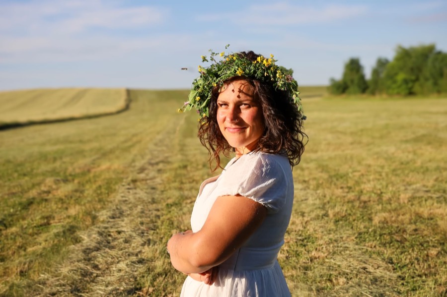 Barbora Štěpánková s věncem z lučních květů na posekaném poli